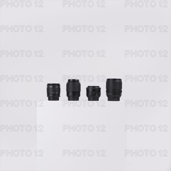 Camera lenses arranged white block against isolated white background