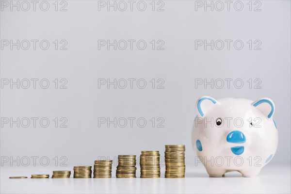 Piggybank increasing stacked coins reflective desk