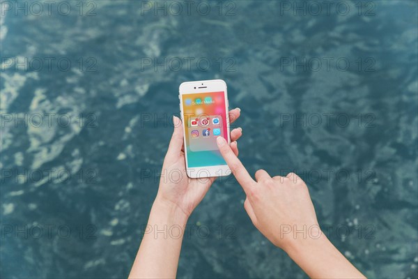 Woman s hand using cellphone with social media notifications screen