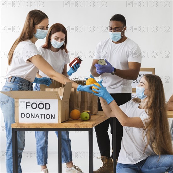 Volunteers with medical masks preparing donation boxes