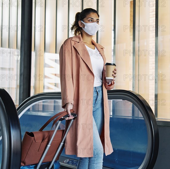 Woman with luggage medical mask airport during pandemic