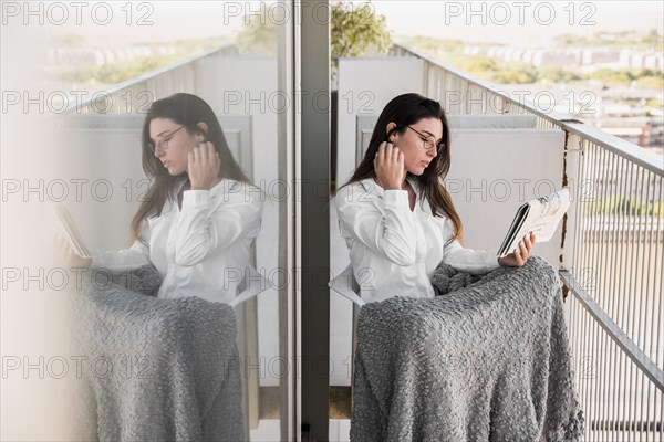 Young woman sitting chair reading newspaper