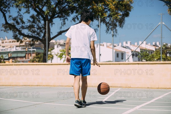 Teenager playing with ball court