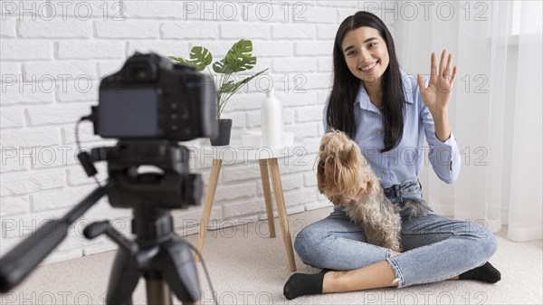 Female influencer home vlogging with dog