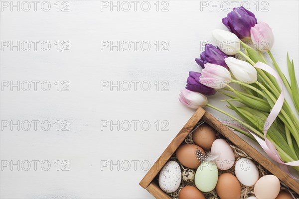 Top view box with eggs easter multicolored tulips