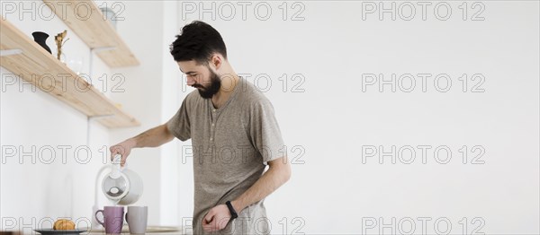 Man pouring hot water mugs