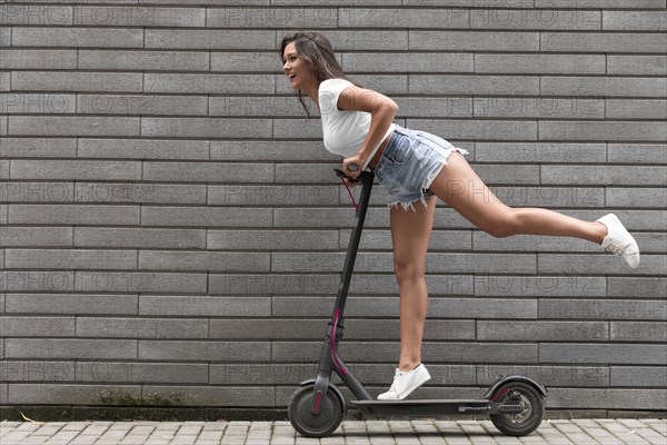 Side view happy woman posing electric scooter