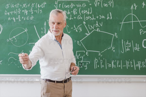 Sociable male teacher standing blackboard pointing by hand