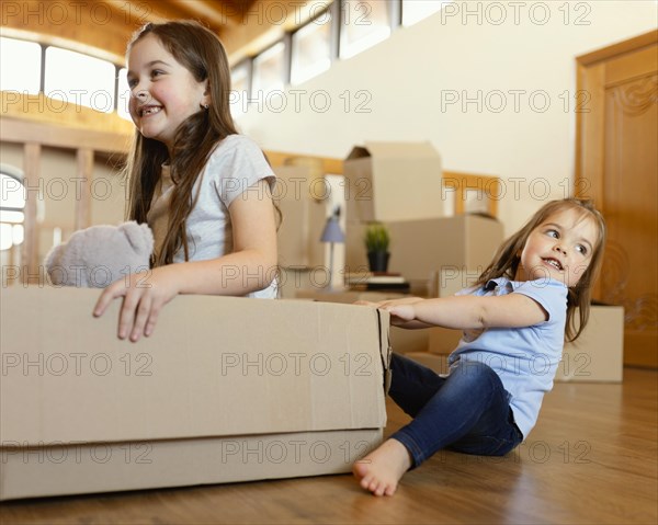 Smiley kids playing with box
