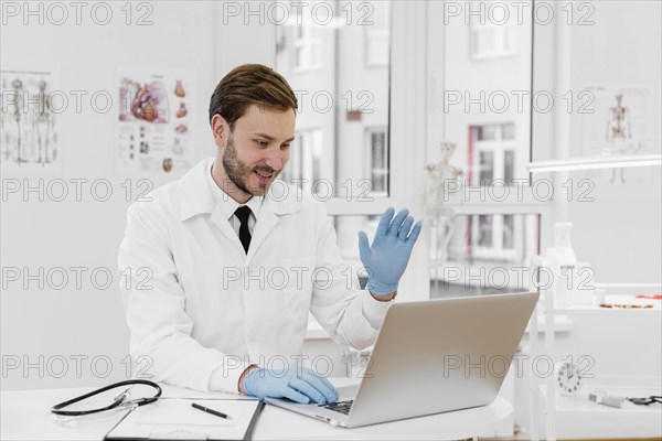 Medium shot doctor working laptop