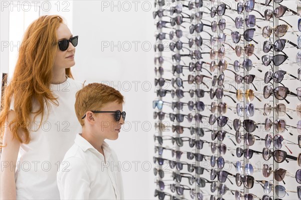 Young woman boy standing together optics showroom