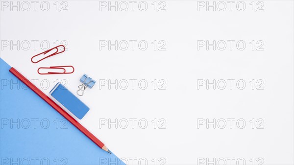 Pencil eraser paper clip with blue card paper white backdrop