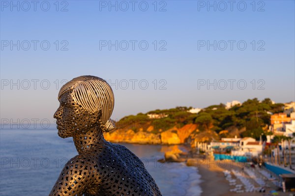 A metal sculpture by artist Carlos de Oliveira Correia looks out over the Atlantic Ocean from the viewing platform on Olhos des Augua beach shortly after sunrise.