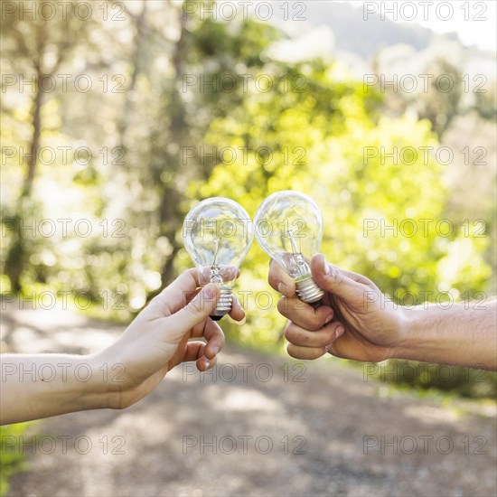 Concept clinking bulbs hands nature