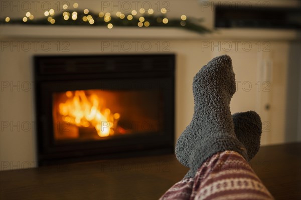 Person with cozy clothes near fireplace