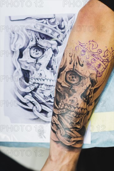 Arm with tattoo near sketch