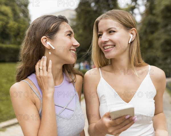 Girls wearing airpods park