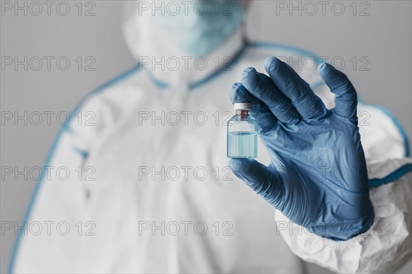 Front view doctor holding vaccine bottle