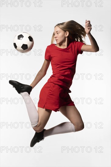 Female football player kicking ball