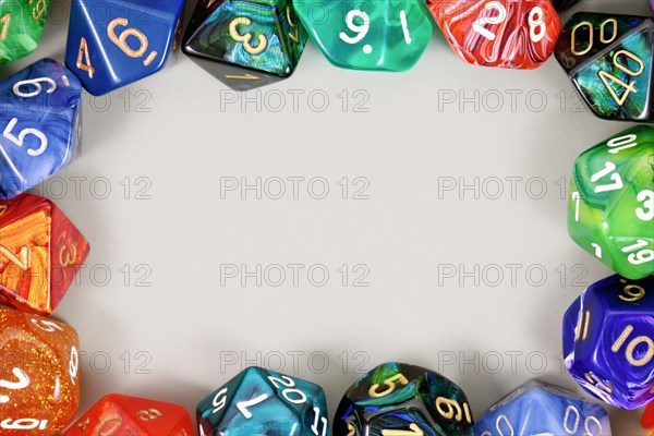 Colorful role playing RPG dice forming border around gray background with copy space