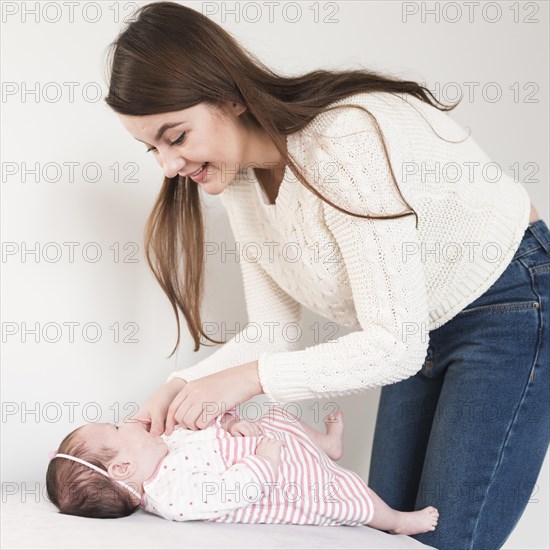 Cheerful woman taking care baby