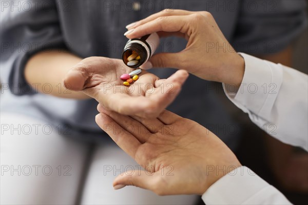 Covid recovery center female doctor giving elder patient pills from bottle hand