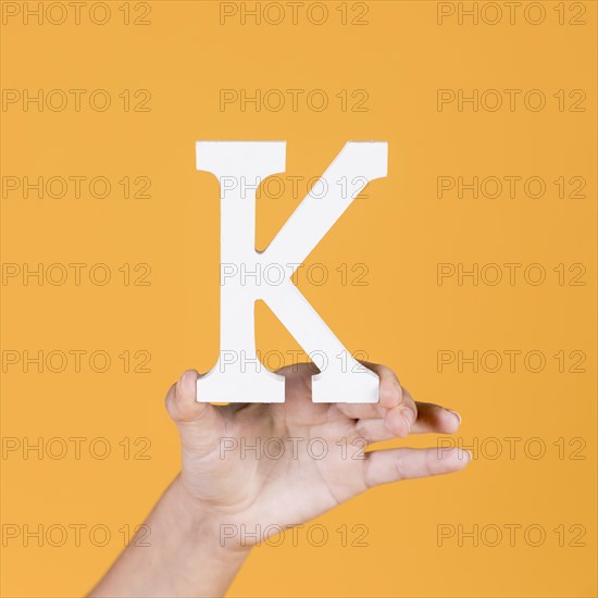 Woman s hand holding up capital alphabet k