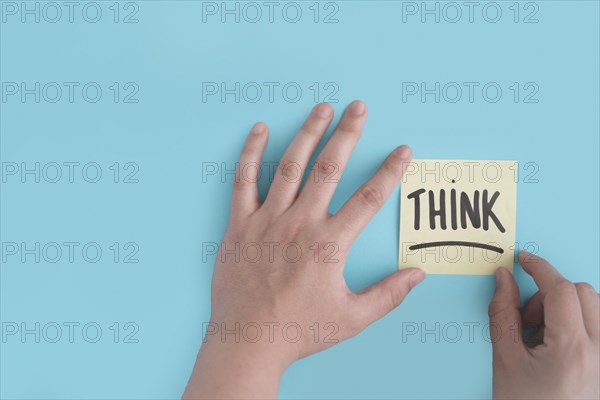Hand sticking think adhesive note blue background