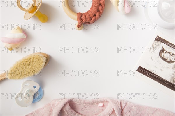 Marshmallow pink baby onesie brush pacifier milk bottle toy white background