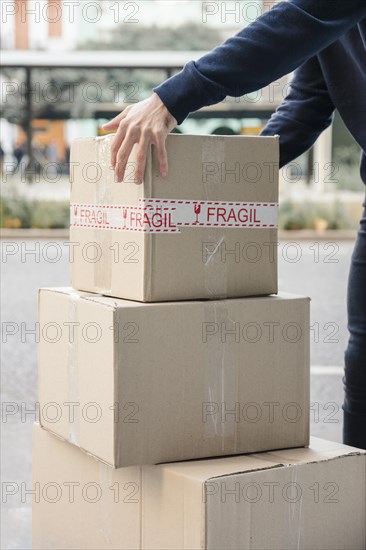 Close up delivery man s hand picking up cardboard box