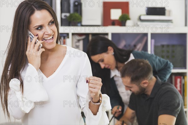 Cheerful woman talking phone celebrating