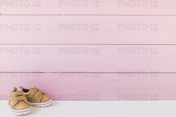 Newborn concept with shoes space wooden surface