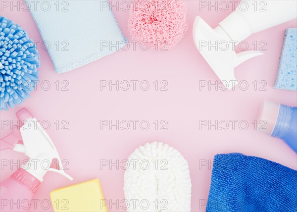 Elevated view cleaning supplies pink backdrop