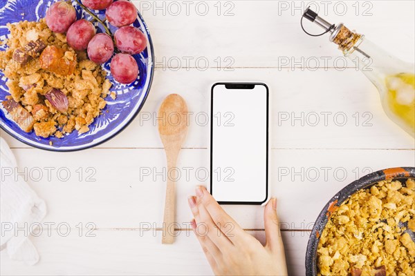 Food plates hand with mobile phone cooking table