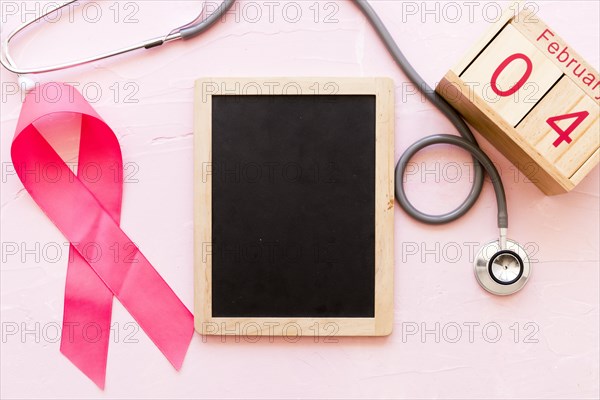 World cancer day awareness ribbon with stethoscope wooden slate 4th february wooden box
