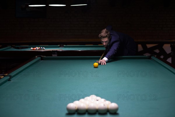 Medium shot man suit playing billiard