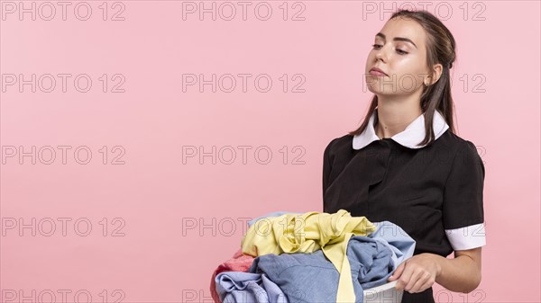 Side view tired woman carrying laundry basin