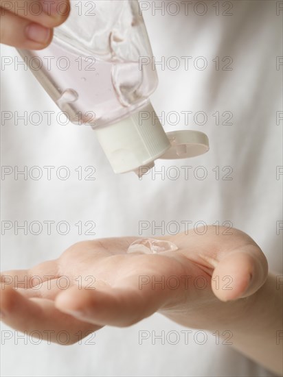 Front view child using hand sanitizer