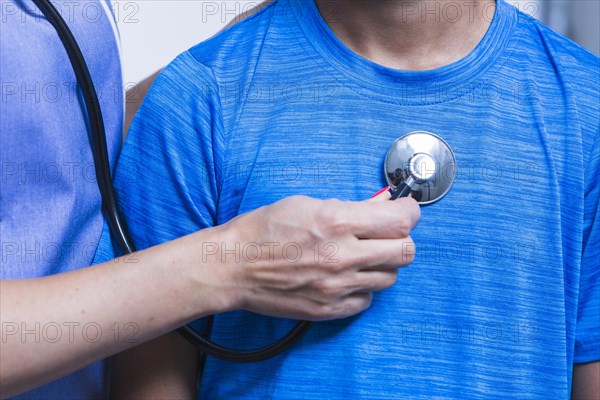 Close up dentist hand examining patient with stethoscope