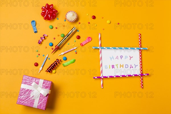 Red ribbon bow aalaw gems streamers sprinkles with happy birthday card gift box yellow backdrop