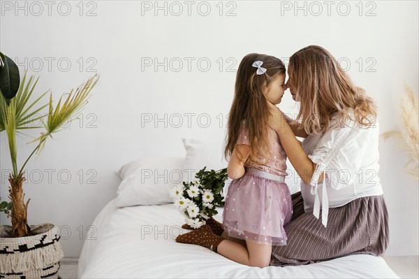 Side view mother daughter with bouquet spring flowers