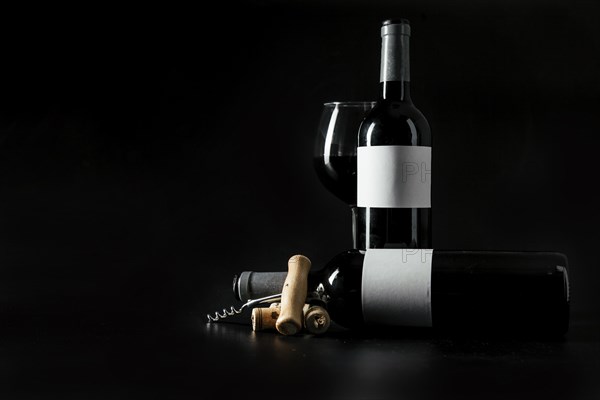 Corkscrew corks near bottles wineglass