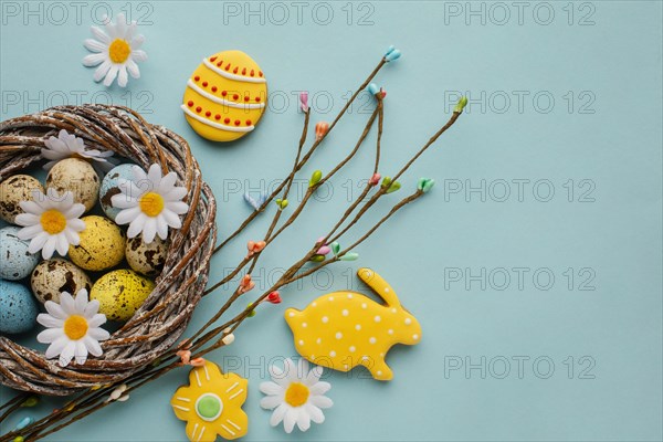 Flat lay easter eggs basket with chamomile flowers