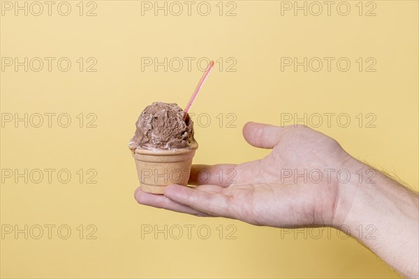 Hand holding little ice cream chocolate scoop