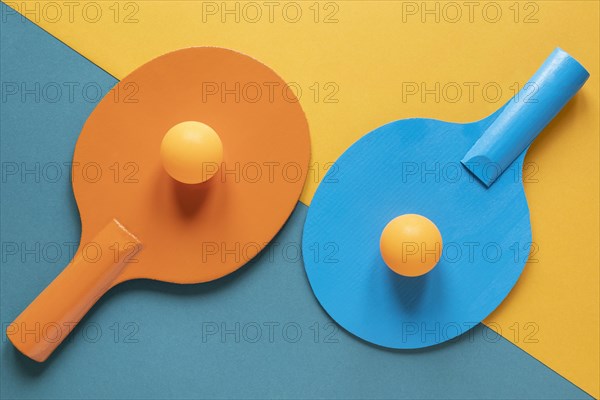 Top view two ping pong paddles with new balls