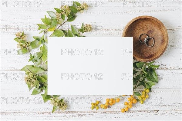 Wedding white card rings flowers yellow berries white wooden desk