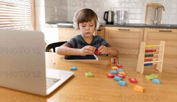 Child wearing headphones attending virtual classes