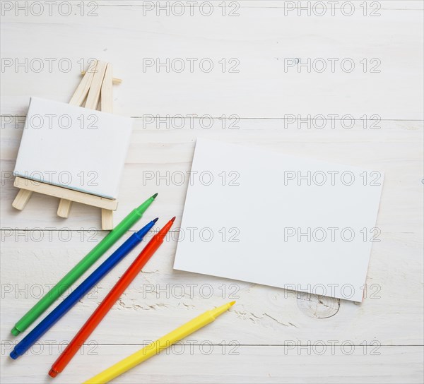 Blank mini easel white paper colors felt tip pen wooden texture backdrop