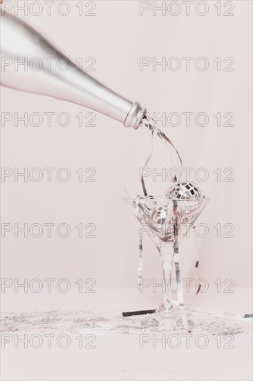 Champagne bottle pouring tinsel glass