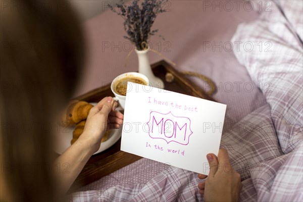 Woman holding greeting card coffee cup tray